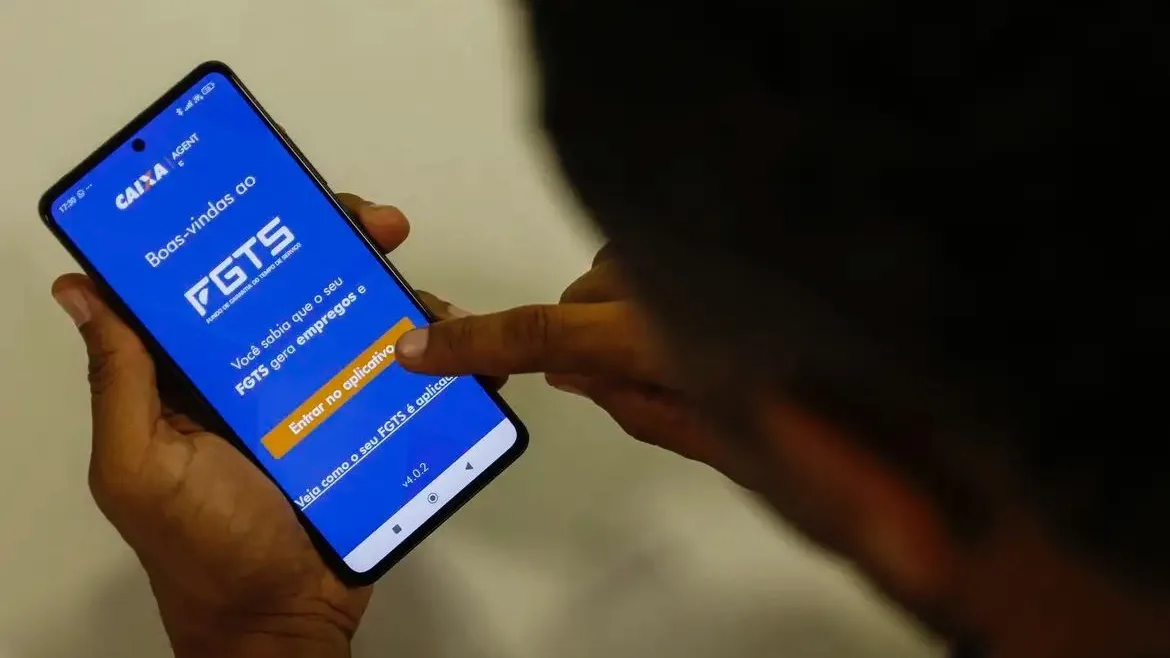 Trabalhadora consultando o aplicativo FGTS no celular
